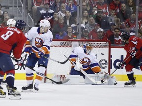 Washington Capitals left wing Alex Ovechkin, left, from Russia, assists as Washington Capitals right wing T.J. Oshie, right, scores a goal past New York Islanders goaltender Jaroslav Halak (41), from Slovakia, in the first period of an NHL hockey game, Friday, March 16, 2018, in Washington.