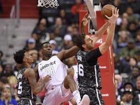 Washington Wizards center Ian Mahinmi (28) reaches for the ball as San Antonio Spurs center Pau Gasol (16), of Spain, grabs a rebound during the first half of an NBA basketball game, Tuesday, March 27, 2018, in Washington. At left is Spurs guard Dejounte Murray.