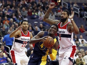 Indiana Pacers guard Victor Oladipo (4) drives between Washington Wizards forwards Otto Porter Jr. (22) and Markieff Morris (5) during the first half of an NBA basketball game Sunday, March 4, 2018, in Washington.