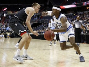 Davidson forward Peyton Aldridge, left, defends as Rhode Island guard Stanford Robinson drives with the ball during the first half of an NCAA college basketball championship game in the Atlantic 10 Conference tournament, Sunday, March 11, 2018, in Washington.