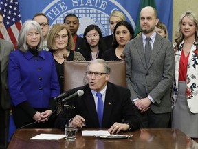 Washington Gov. Jay Inslee, center, speaks before signing a bill Monday, March 5, 2018, in Olympia, Wash., that makes Washington the first state to set up its own net-neutrality requirements in response to the Federal Communications Commission's recent repeal of Obama-era rules. The FCC voted in December to gut U.S. rules that meant to prevent broadband companies such as Comcast, AT&T and Verizon from exercising more control over what people watch and see on the internet.