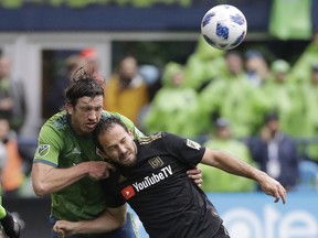 Seattle Sounders defender Gustav Svensson, left, heads the ball away from Los Angeles forward Marco Urena during the second half of an MLS soccer match, Sunday, March 4, 2018, in Seattle. Los Angeles won 1-0.