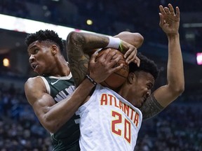 Milwaukee Bucks' Giannis Antetokounmpo ties up Atlanta Hawks' John Collins during the first half of an NBA basketball game Saturday, March 17, 2018, in Milwaukee.