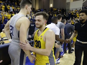 Marquette guard Andrew Rowsey (30) shakes hands with Penn State's John Harrar after Penn State's 85-80 win in an NCAA college basketball game in the NIT on Tuesday, March 20, 2018, in Milwaukee.