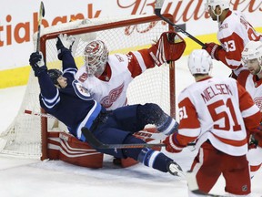 Matt Hendricks of the Edmonton Oilers crashes into Detroit Red Wings goaltender Jimmy Howard during NHL action Friday night in Winnipeg. The Jets were 4-3 winners.