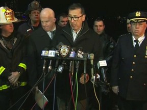 In this image made from video provided by WNYW, New York City Fire Department Commissioner Daniel Nigro speaks during a press conference a deadly helicopter crash in New York on Sunday, March 11, 2018. A helicopter crashed into New York City's East River Sunday night and flipped upside down in the water, killing at least a few people aboard and leaving some others in critical condition, officials said. New York City Police Commissioner James O'Neill stands at center left. (WNYW via AP)