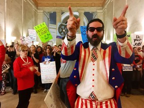 FILE - In this March 1, 2018 file photo, Parry Casto, a fifth grade teacher at the Explorer Academy in Huntington, W.Va., dressed in an Uncle Sam costume leads hundreds of teachers in chants outside the state Senate chambers at the Capitol in Charleston, W.Va  The strike rolled into its second weekend with the state Senate planning to meet Saturday, March 3 after declining to take a vote on whether the teachers will get the 5 percent pay raise negotiated by Gov. Jim Justice and union leaders.