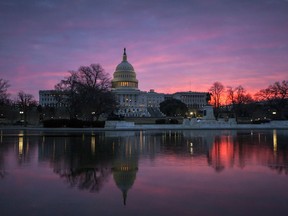 In this Feb. 6, 2018 photo, dawn breaks over the Capitol in Washington.  Money's not really the holdup in talks on a huge $1.3 trillion catchall spending bill that's making its way through Capitol Hill. But battles over abortion, President Donald Trump's U.S.-Mexico border wall _ and Trump's threat to veto the entire bill over an expensive railway project sought by his most powerful Democratic rival are roiling negotiations on the massive measure.