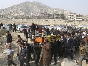 FILE - In this Jan. 28, 2018, file photo, men carry the coffin of a relative who died in the Jan. 27 deadly suicide attack in Kabul, Afghanistan. The deadly explosion caused by a suicide bomber driving an ambulance in the capital. Is Afghanistan really America's forgotten war? Consider this: At a Senate hearing this week on top U.S. security threats, the word "Afghanistan" was spoken exactly four times, each during introductory remarks. In the ensuing two hours of questions for intelligence agency witnesses, no senator asked about Afghanistan, suggesting little interest in a 17-year war with nearly 15,000 U.S. troops supporting combat against the Taliban.