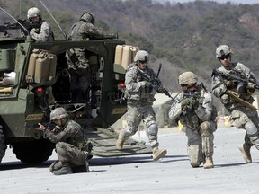 FILE - In this March 25, 2015, file photo, U.S. Army soldiers from the 25th Infantry Division's 2nd Stryker Brigade Combat Team and South Korean soldiers take their position during a demonstration of the combined arms live-fire exercise as a part of the annual joint military exercise Foal Eagle between South Korea and the United States at the Rodriquez Multi-Purpose Range Complex in Pocheon, north of Seoul, South Korea. The Pentagon says the annual U.S.-South Korean military exercises that had been postponed for the Pyeongchang Winter Olympics will begin April 1.