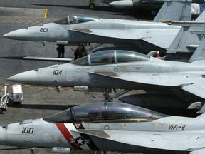 FILE - In this March 3, 2017 file photo, a row of F18 fighter jets are shown on the deck of the U.S. Navy aircraft carrier USS Carl Vinson (CVN 70)  off the disputed South China Sea.  Navy officials say a fighter jet has crashed off the coast of Key West, Florida, and rescue efforts are underway. The officials say the F/A-18 Hornet's two crew members ejected and are based out of Naval Air Station Oceana, in Virginia Beach, Va.