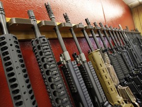 FILE - In this July 20, 2012, file photo, a row of different AR-15 style rifles are displayed for sale at the Firing-Line indoor range and gun shop in Aurora, Colo. A measure strengthening the federal background check system for gun purchases will be included in the $1.3 trillion government spending bill being negotiated by congressional leaders, aides say. The "Fix NICS" measure would provide funding for states to comply with the existing National Instant Criminal Background Check system and penalize federal agencies that don't comply.