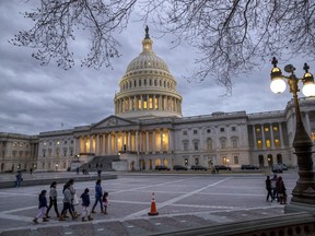 FILE - In this Jan. 21, 2018 file photo, people walk by the U.S. Capitol on the second day of the federal shutdown as lawmakers negotiate behind closed doors in Washington.  After last year's big win on taxes, Republicans controlling Capitol Hill are opting for a scaled-back, controversy-free agenda. President Donald Trump's trillion dollar-plus plan to boost infrastructure has landed with a thud. Hopes in the House of taking on so-called welfare reform seem likely to fizzle in the Senate. Instead, the GOP-controlled Congress is looking ahead to a year of abbreviated work weeks and low-profile and small-bore initiatives.