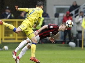AC Milan's Lucas Biglia, right, challenges for the ball with Chievo's Mariusz Stepinski during the Serie A soccer match between AC Milan and Chievo Verona at the San Siro stadium in Milan, Italy, Sunday, March 18, 2018.