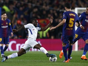 Chelsea's Victor Moses, center left, vies for the ball with Barcelona's Sergio Busquets during the Champions League round of sixteen second leg soccer match between FC Barcelona and Chelsea at the Camp Nou stadium in Barcelona, Spain, Wednesday, March 14, 2018.