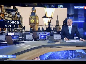 In this video grab provided by RU-RTR Russian television on Sunday, March 11, 2018, Dimtry Kiselev, one of Russia's most powerful media figures, speaks during his Sunday news program on state-owned TV channel Rossiya-1, in Moscow, Russia. His segment about former Russian Double agent Sergei Skripal and his daughter who were poisoned in Britain a week ago, was in sync with a reflexive response of Russian officials to attribute nearly all criticism from the West to anti-Russia bias. The words at top left read "death trap". (RU-RTR Russian Television via AP)