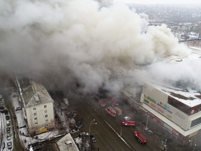 In this Russian Emergency Situations Ministry photo, on Sunday, March 25, 2018, smoke rises above a multi-story shopping center in the Siberian city of Kemerovo, about 3,000 kilometers (1,900 miles) east of Moscow, Russia. At least three children and a woman have died in a fire that broke out in a multi-story shopping center in the Siberian city of Kemerovo. (Russian Ministry for Emergency Situations photo via AP)