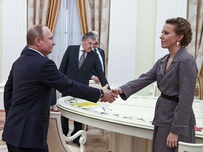 Russian President Vladimir Putin, left, greets Ksenia Sobchak, right, during his meeting with opposition candidates who ran against him in Sunday's presidential election, Boris Titov, Sergei Baburin, Maxim Suraykin, Vladimir Zhirinivsky, Pavel Grudinin, and Grigory Yavlinsky, at the Kremlin in Moscow, Russia, Monday, March 19, 2018. Putin, who won a landslide victory in Sunday's vote, said during a Kremlin meeting with seven other candidates who challenged him, that the focus should now be on raising living standards and solving other domestic issues.