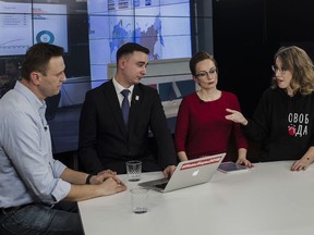 Russian opposition leader Alexei Navalny, left, discusses with Presidential candidate Ksenia Sobchak, right, as they observe election progress at the Foundation for Fighting Corruption office, in Moscow, Russia, Sunday, March 18, 2018. An exit poll suggests that Vladimir Putin has handily won a fourth term as Russia's president, adding six more years in the Kremlin for the man who has led the world's largest country for all of the 21st century.