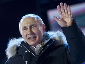 Russian President Vladimir Putin waves after speaking to supporters during a rally near the Kremlin in Moscow, Sunday, March 18, 2018.