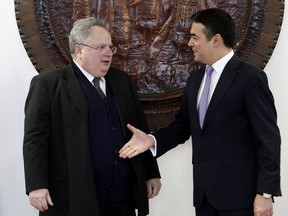 Greece's Foreign Minister Nikos Kotzias, left, shakes hands with his Macedonian counterpart Nikola Dimitrov while posing for the media upon his arrival at the foreign ministry building in Skopje, Macedonia, Friday, March 23, 2018. Greece's foreign minister arrived in Macedonia for talks on resolving a decades-long dispute over the former Yugoslav republic's name.