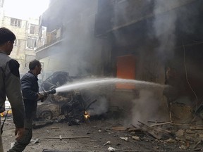 This photo released by the Syrian Civil Defense White Helmets, which has been authenticated based on its contents and other AP reporting, Civil Defense workers putting out a fire following airstrikes and shelling in Douma, in the eastern Ghouta region near Damascus, Syria, Tuesday, March. 20, 2018. The U.N. refugee agency says 45,000 Syrians have left their homes in the besieged region of eastern Ghouta in recent days, amid a Syrian government-led offensive against the rebel-held area. (Syrian Civil Defense White Helmets via AP)