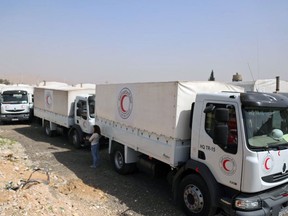 This photo released by the Syrian Red Crescent shows a convoy of vehicles of the Syrian Red Crescent arriving to Douma, eastern Ghouta, a suburb of Damascus, Syria, Monday, March. 5, 2018. Desperate for food and medicine, Syrian civilians in the war-ravaged eastern suburbs of Damascus hoped for relief Monday as a 46-truck aid convoy began entering the rebel stronghold, the first such shipment in months. (Syrian Red Crescent via AP)