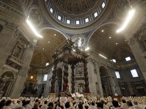 Pope Francis, small white figure sitting beneath the baldachin, celebrates a Chrism Mass inside St. Peter's Basilica, at the Vatican, Thursday, March 29, 2018. During the Mass the pontiff blesses a token amount of oil that will be used to administer the sacraments for the year.