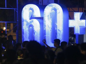 Filipinos gather at the Cultural Center of the Philippines to take part in an Earth Hour activity, a global even that raises awareness on the need to take action on climate change Saturday, March 24, 2018 in suburban Pasay city southeast of Manila, Philippines. The annual event urges people all over the world to switch off the lights in their homes and workplaces for at least an hour.