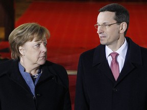 Poland's Prime Minister Mateusz Morawiecki,right, greets German Chancellor Angela Merkel before talks on European Union future and security and on bilateral ties at his office in Warsaw, Poland, Monday, March 19, 2018. Merkel was sworn in for her fourth term last week.