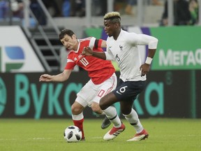 France's Paul Pogba, right, duels for the ball with Russia's Fyodor Smolov during the international friendly soccer match between Russia and France at the Saint Petersburg stadium in St.Petersburg, Russia, Tuesday, March 27, 2018.