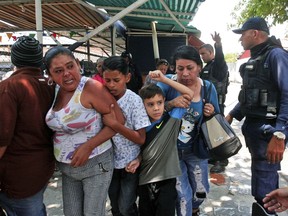 Police officers disperse the relatives of prisoners who were waiting to hear news about their family members imprisoned at a police station when a riot broke out, in Valencia, Venezuela, Wednesday, March 28, 2018.