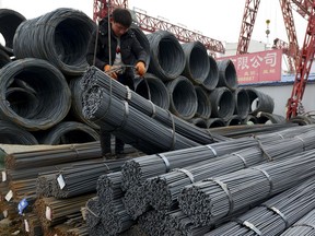 A worker loads steel products onto a vehicle at a steel market in Fuyang in central China's Anhui province Friday, March 2, 2018. China has expressed "grave concern" about a U.S. trade policy report that pledges to pressure Beijing but had no immediate response to President Donald Trump's plan to hike tariffs on steel and aluminum. The Commerce Ministry said Friday that Beijing has satisfied its trade obligations and appealed to Washington to settle disputes through negotiation (Chinatopix Via AP)