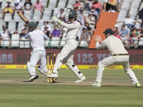 Quinton De Kock of South Africa, left, in action on the fourth day of the third cricket test between South Africa and Australia at Newlands Stadium, in Cape Town, South Africa, Sunday, March 25, 2018.