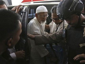 Ailing radical cleric Abu Bakar Bashir, center, arrives for medical treatment at the Cipto Mangunkusumo Hospital in Jakarta, Indonesia, Thursday, March 1, 2018. Bashir who was the spiritual leader of the Bali bombers and the force behind a jihadist training camp in 2010, has been transferred from prison to the hospital. The octogenarian cleric suffers from a host of medical problem including chronically weak blood circulation.