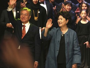 South Korean President Moon Jae-in, left, waves to a crowd with his wife Kim Jung-sook in Abu Dhabi, United Arab Emirates, Monday, March 26, 2018. On Monday, Jae-in visited a new nuclear power plant his country is helping build in the United Arab Emirates and watched a cultural performance later that night in Abu Dhabi, the UAE's capital.