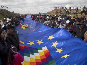 People wave a portion of a giant Bolivian Naval flag on the highway between Oruro and La Paz Bolivia, Saturday, March 10, 2018. A narrow strip of blue stretched for more than 150 miles (nearly 200 kilometers) across the nation Saturday, as part of a demonstration of the country's demand for an outlet to the sea. Bolivia lost its only seacoast to Chile in a war in the late 1800's and has asked the World Court to order Chile to negotiate a settlement in good faith.