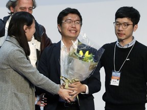 Hong Kong pro-democracy by-election candidate Au Nok-hin, center, celebrates with his supporters after winning a seat at the legislative council by-elections in Hong Kong, Monday, March 12, 2018.