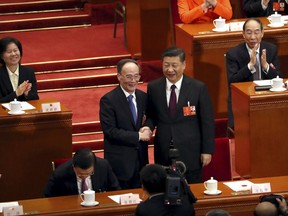 Chinese President Xi Jinping, right, shakes hands with Wang Qishan after Wang was elected Vice-President during a plenary session of China's National People's Congress (NPC) in Beijing, Saturday, March 17, 2018. China's rubber-stamp legislature has appointed a close ally of President Xi Jinping to the formerly ceremonial post of vice president. The appointment of Wang Qishan is expected to further Xi's agenda of shoring up Communist Party rule while ending corruption and poverty.