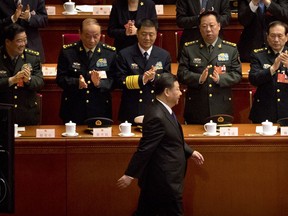 Military delegates applaud as Chinese President Xi Jinping arrives during a plenary meeting of China's National People's Congress (NPC) at the Great Hall of the People in Beijing, Sunday, March 18, 2018. China's ceremonial legislature appointed Premier Li Keqiang, the No. 2 leader of the ruling Communist Party, to a second five-year term Sunday and approved the appointment of a director for a new anti-corruption agency with sweeping powers.