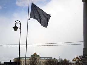 The European Union flag flies in front of the European Union mission with the Kremlin in the background, in Moscow, Russia, Wednesday, March 28, 2018. More than 20 nations have expelled over 150 Russian diplomats this week in a show of solidarity with Britain over the poisoning of a former Russian spy and Moscow has pledged to retaliate.