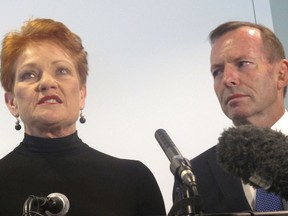 One Nation party leader Pauline Hanson, left, launches her book as former Prime Minister Tony Abbott listens at Parliament House in Canberra, Australia, Tuesday, March 27, 2018. Abbott hinted that he still holds leadership ambitions as his replacement struggles to turn around the government's disastrous opinion polling.