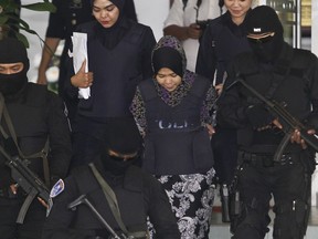 Indonesian Siti Aisyah, second from right, is escorted by police as she leaves a court hearing at Shah Alam High Court in Shah Alam, Malaysia, Wednesday, March 14, 2018. Aisyah and Doan of Vietnam have pleaded not guilty of killing Kim Jong Nam on Feb. 13, 2017 at a crowded Kuala Lumpur airport terminal. They are accused of wiping VX on Kim's face in an assassination widely thought to have been orchestrated by North Korean leader Kim Jong Un.