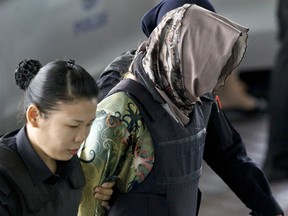 Vietnamese Doan Thi Huong, right, is escorted by police as she arrives for a court hearing at Shah Alam High Court in Shah Alam, Malaysia, Thursday, March 22, 2018. Doan and co-defendant Siti Aisyah from Indonesia were charged with murdering Kim Jong Nam, the estranged half brother of North Korean leader Kim Jong Un, at Kuala Lumpur's airport on Feb. 13 last year. The two are the only suspects in custody, though prosecutors have said four North Koreans who fled the country were also involved.