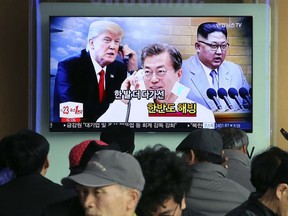 FILE - In this March 7, 2018, file photo, people watch a TV screen showing images of North Korean leader Kim Jong Un, right, South Korean President Moon Jae-in, center, and U.S. President Donald Trump at the Seoul Railway Station in Seoul, South Korea. South Korean President Moon Jae-in has always wanted to lead the diplomacy aimed at ending the North Korean nuclear crisis, even as he was overshadowed in his first year in office by a belligerent standoff between Donald Trump and Kim Jong Un. Korean letters on the screen read: "Thawing Korean Peninsula."