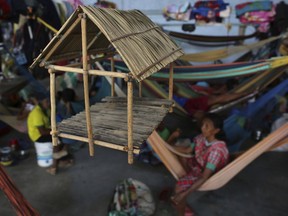 This March 10, 2018 photo shows an adornment depicting a traditional Warao thatched roof hut made from palm fibers, hanging inside a shelter in Pacaraima, the main entry point for Venezuelans in the Brazilian northern state Roraima. Traditionally poor and marginalized in Venezuela, the Warao are fleeing the economic and political crisis in their native land and arriving daily in Pacaraima.