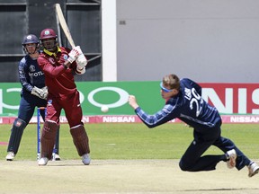 West Indies batsman Marlon Samuels, right, plays a shot as Scotland bowler Michael Leask, right, attempts a catch during their cricket world cup qualifier match at Harare Sports Club, Wednesday, March, 21, 2018. Zimbabwe is playing host to the 2018 Cricket World Cup Qualifier matches featuring 10 countries.