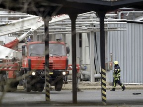 REMOVES THE NAME OF THE CHEMICAL FACTORY A firefighter walks at the site of an explosion in a chemical plant in Kralupy nad Vltavou, Czech Republic, Thursday, March 22, 2018. Vladimira Kerekova, spokeswoman for the regional firefighters, says an explosion in a chemical factory, north of Prague, the Czech Republic has killed six people and injured an unspecified number.