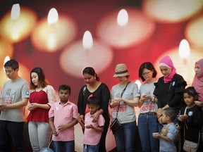Relatives of passengers on board the missing Malaysia Airlines Flight 370 have a moment of silence during the Day of Remembrance for MH370 event in Kuala Lumpur, Malaysia, Saturday, March 3, 2018.