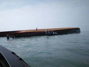 This photo released by Malaysian Maritime Enforcement Agency shows a capsized sand-dredging vessel is seen in the waters near Muar, Johor, Malaysia, Wednesday, March 21, 2018. Malaysia's coast guard says a Chinese sand-dredger capsized off the country's southern coast, killing a crew member and leaving 14 others still missing. (Malaysian Maritime Enforcement Agency via AP)